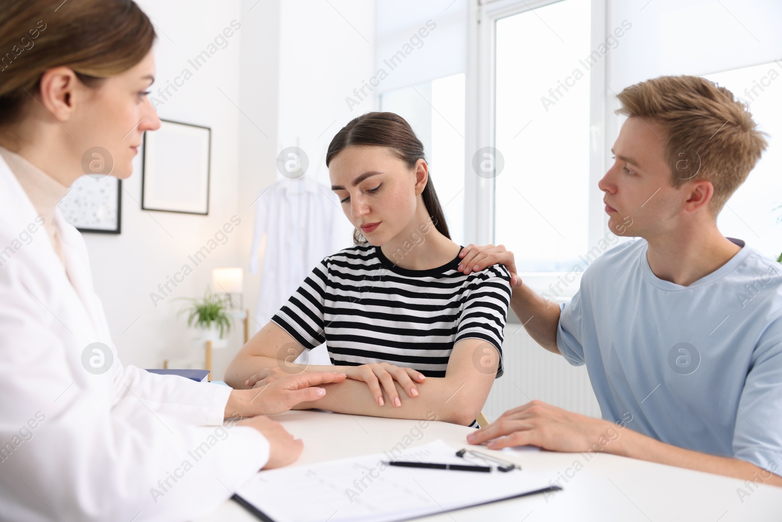 In vitro fertilization (IVF). Doctor supporting upset couple during visit in reproductive clinic Photo of In vitro fertilization (IVF). Doctor supporting upset couple during visit in reproductive clinic