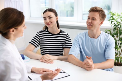 Photo of In vitro fertilization (IVF). Happy couple having appointment with doctor in reproductive clinic