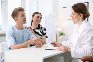 Photo of In vitro fertilization (IVF). Happy couple having appointment with doctor in reproductive clinic