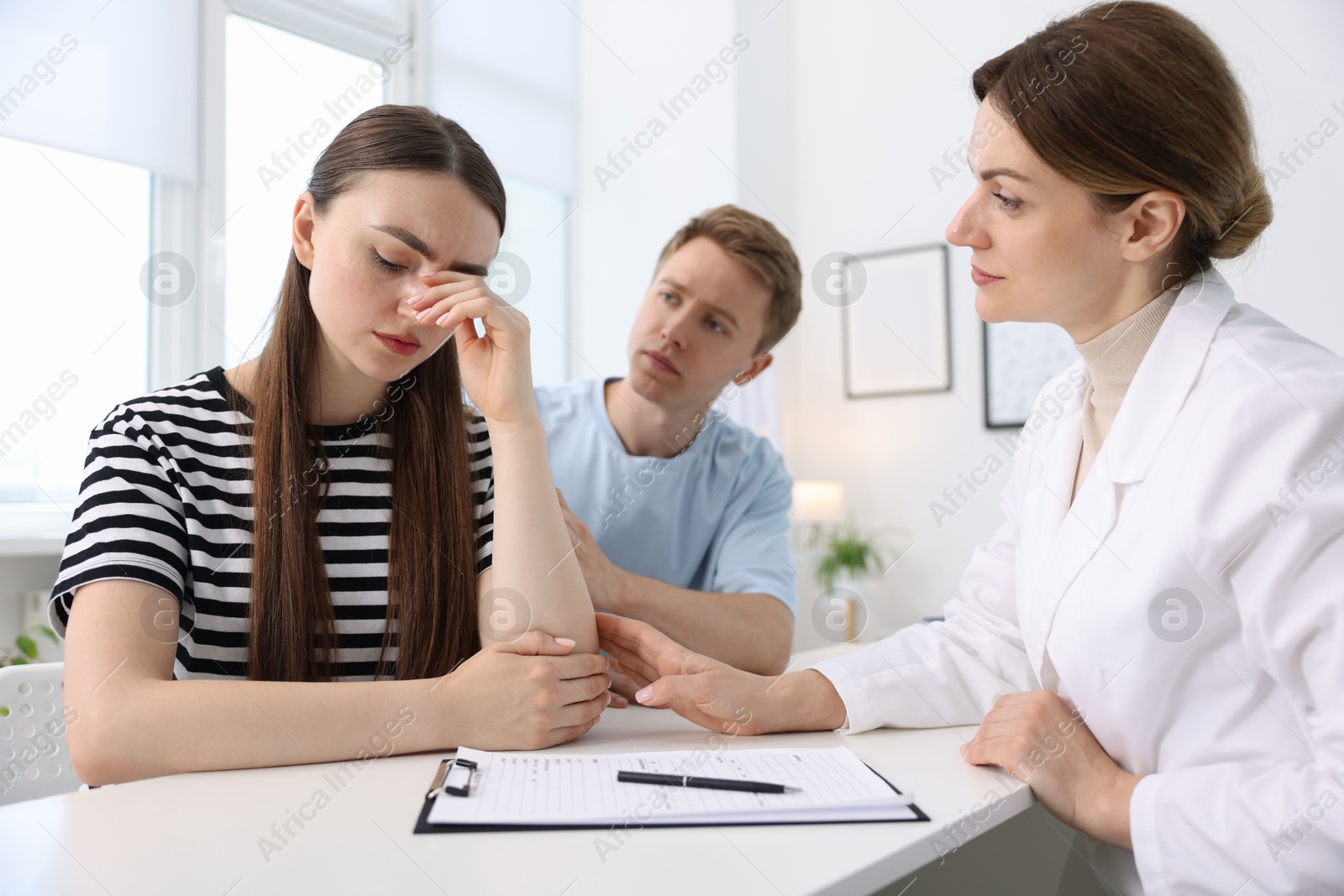 Photo of In vitro fertilization (IVF). Upset couple having appointment with doctor in reproductive clinic