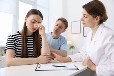 Photo of In vitro fertilization (IVF). Upset couple having appointment with doctor in reproductive clinic
