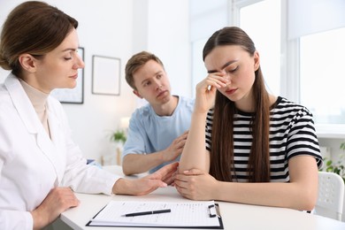 Photo of In vitro fertilization (IVF). Upset couple having appointment with doctor in reproductive clinic