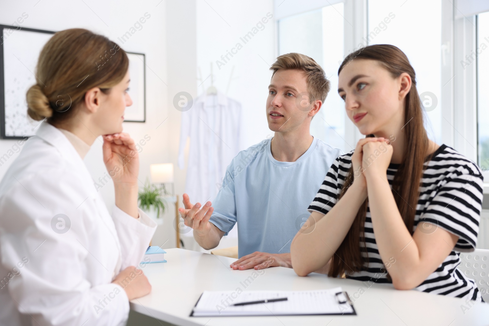 In vitro fertilization (IVF). Couple having appointment with doctor in reproductive clinic Photo of In vitro fertilization (IVF). Couple having appointment with doctor in reproductive clinic