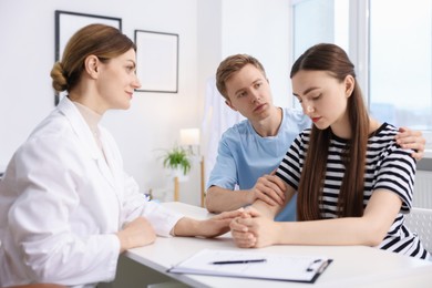 Photo of In vitro fertilization (IVF). Doctor supporting upset couple during visit in reproductive clinic