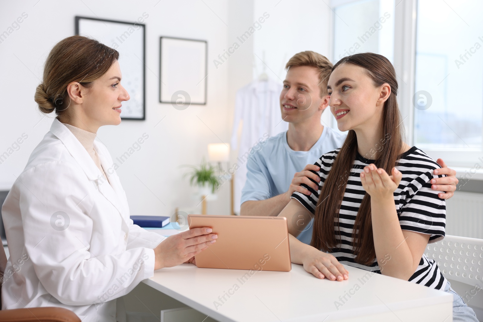 Photo of In vitro fertilization (IVF). Doctor showing couple good results on tablet in reproductive clinic