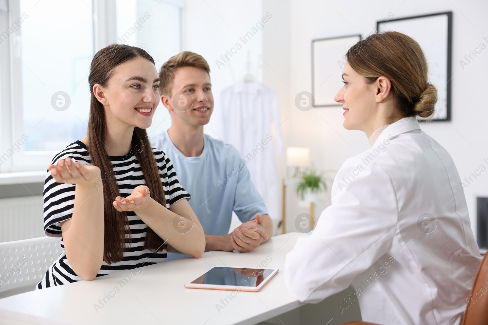 Photo of In vitro fertilization (IVF). Happy couple having appointment with doctor in reproductive clinic