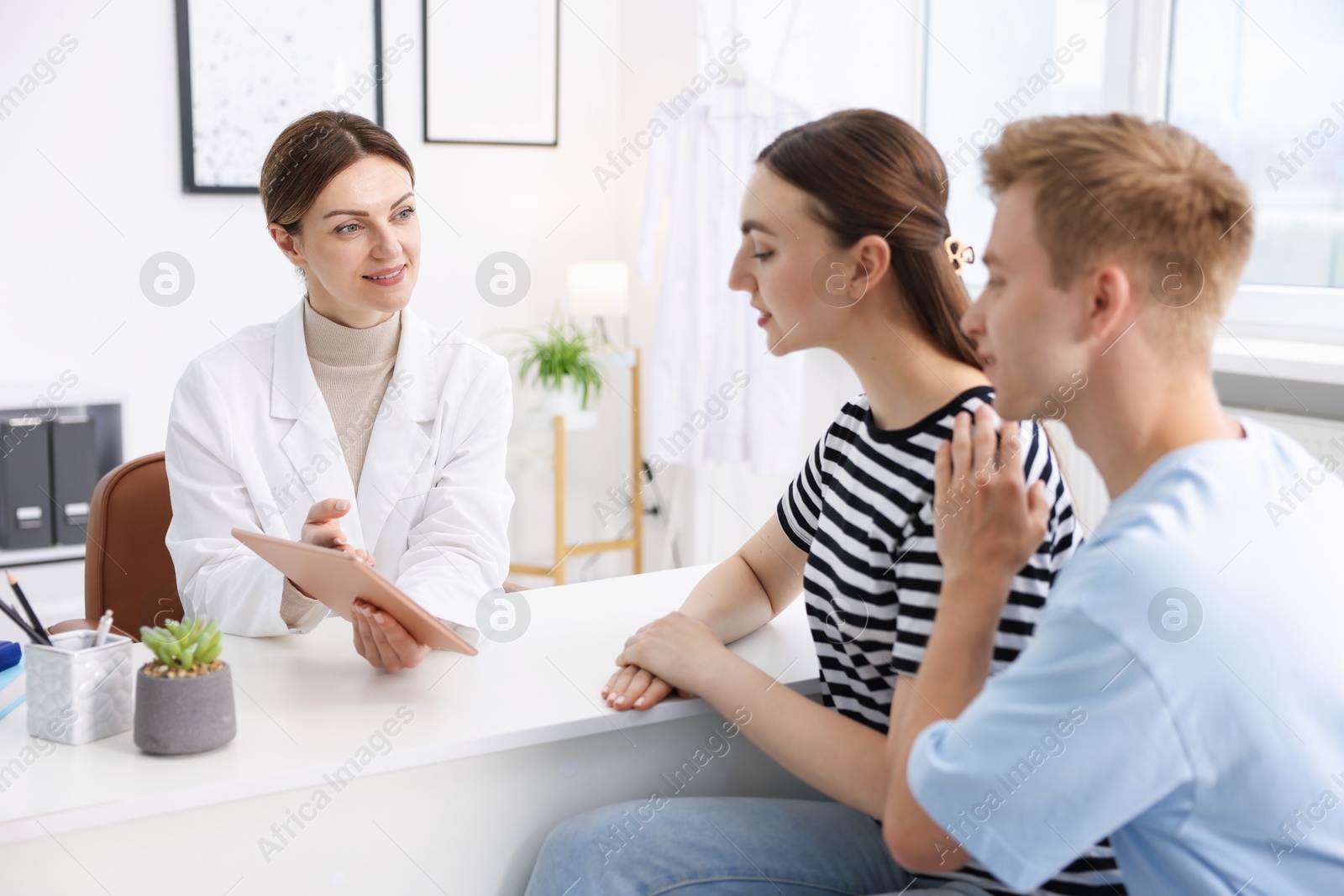 In vitro fertilization (IVF). Couple having appointment with doctor in reproductive clinic Photo of In vitro fertilization (IVF). Couple having appointment with doctor in reproductive clinic