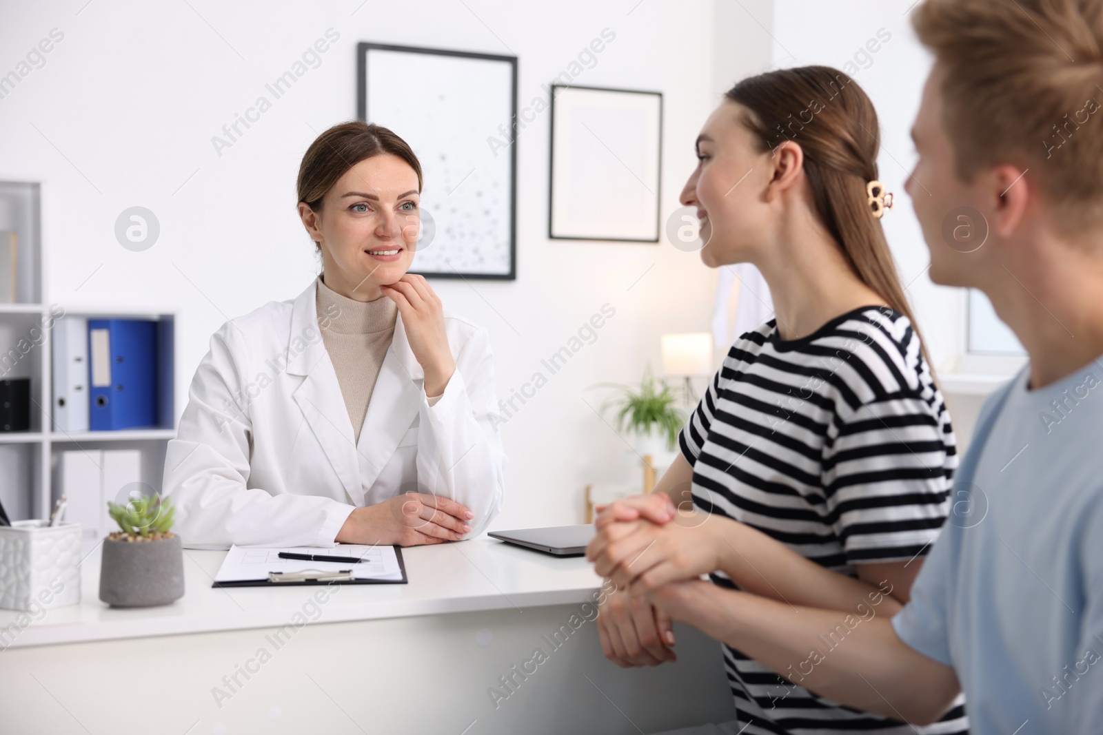 In vitro fertilization (IVF). Couple holding hands during appointment with doctor in reproductive clinic Photo of In vitro fertilization (IVF). Couple holding hands during appointment with doctor in reproductive clinic
