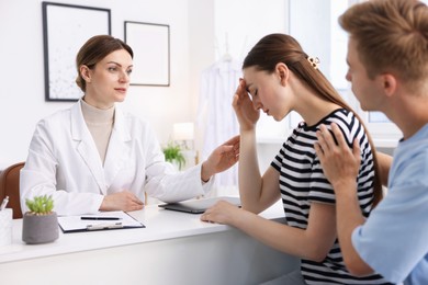 Photo of In vitro fertilization (IVF). Doctor supporting upset couple during visit in reproductive clinic