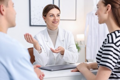 Photo of In vitro fertilization (IVF). Couple having appointment with doctor in reproductive clinic, selective focus