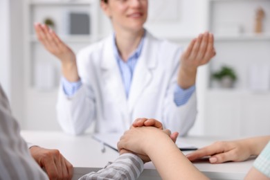 Photo of In vitro fertilization (IVF). Couple holding hands during appointment with doctor in reproductive clinic, closeup