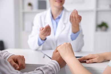 Photo of In vitro fertilization (IVF). Couple holding hands during appointment with doctor in reproductive clinic, closeup