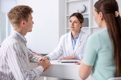 Photo of In vitro fertilization (IVF). Doctor encouraging couple during visit in reproductive clinic