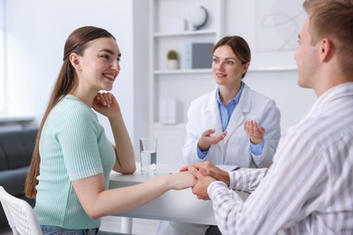Photo of In vitro fertilization (IVF). Couple holding hands during appointment with doctor in reproductive clinic