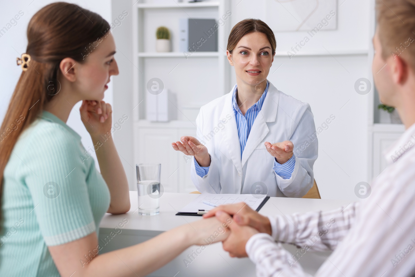 In vitro fertilization (IVF). Couple holding hands during appointment with doctor in reproductive clinic Photo of In vitro fertilization (IVF). Couple holding hands during appointment with doctor in reproductive clinic