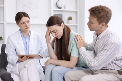 Photo of In vitro fertilization (IVF). Upset couple having appointment with doctor in reproductive clinic