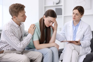 Photo of In vitro fertilization (IVF). Upset couple having appointment with doctor in reproductive clinic