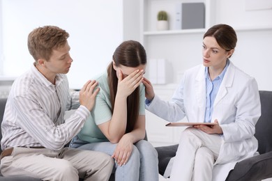 Photo of In vitro fertilization (IVF). Upset couple having appointment with doctor in reproductive clinic