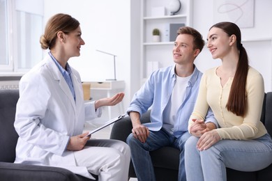 Photo of In vitro fertilization (IVF). Happy couple having appointment with doctor in reproductive clinic