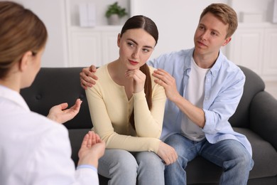 Photo of In vitro fertilization (IVF). Upset couple having appointment with doctor in reproductive clinic