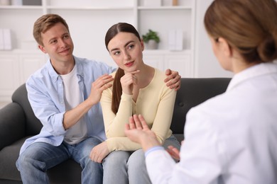 Photo of In vitro fertilization (IVF). Upset couple having appointment with doctor in reproductive clinic