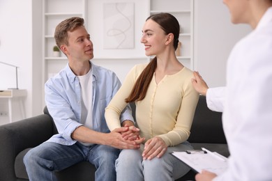 Photo of In vitro fertilization (IVF). Couple holding hands during appointment with doctor in reproductive clinic