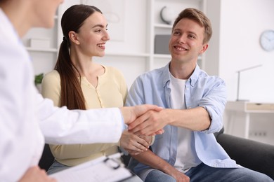 Photo of In vitro fertilization (IVF). Doctor shaking hands with couple in reproductive clinic