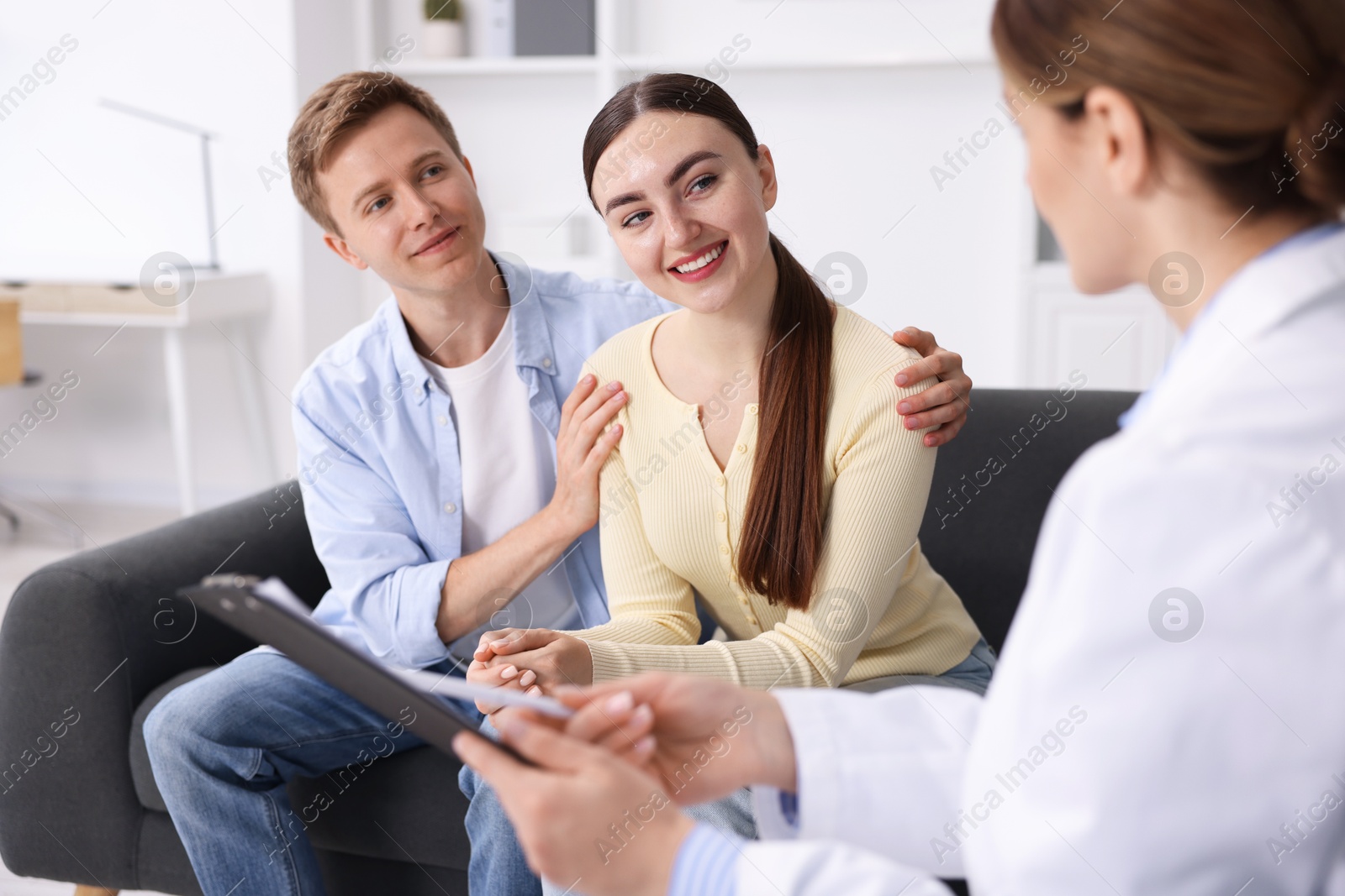 In vitro fertilization (IVF). Happy couple having appointment with doctor in reproductive clinic Photo of In vitro fertilization (IVF). Happy couple having appointment with doctor in reproductive clinic