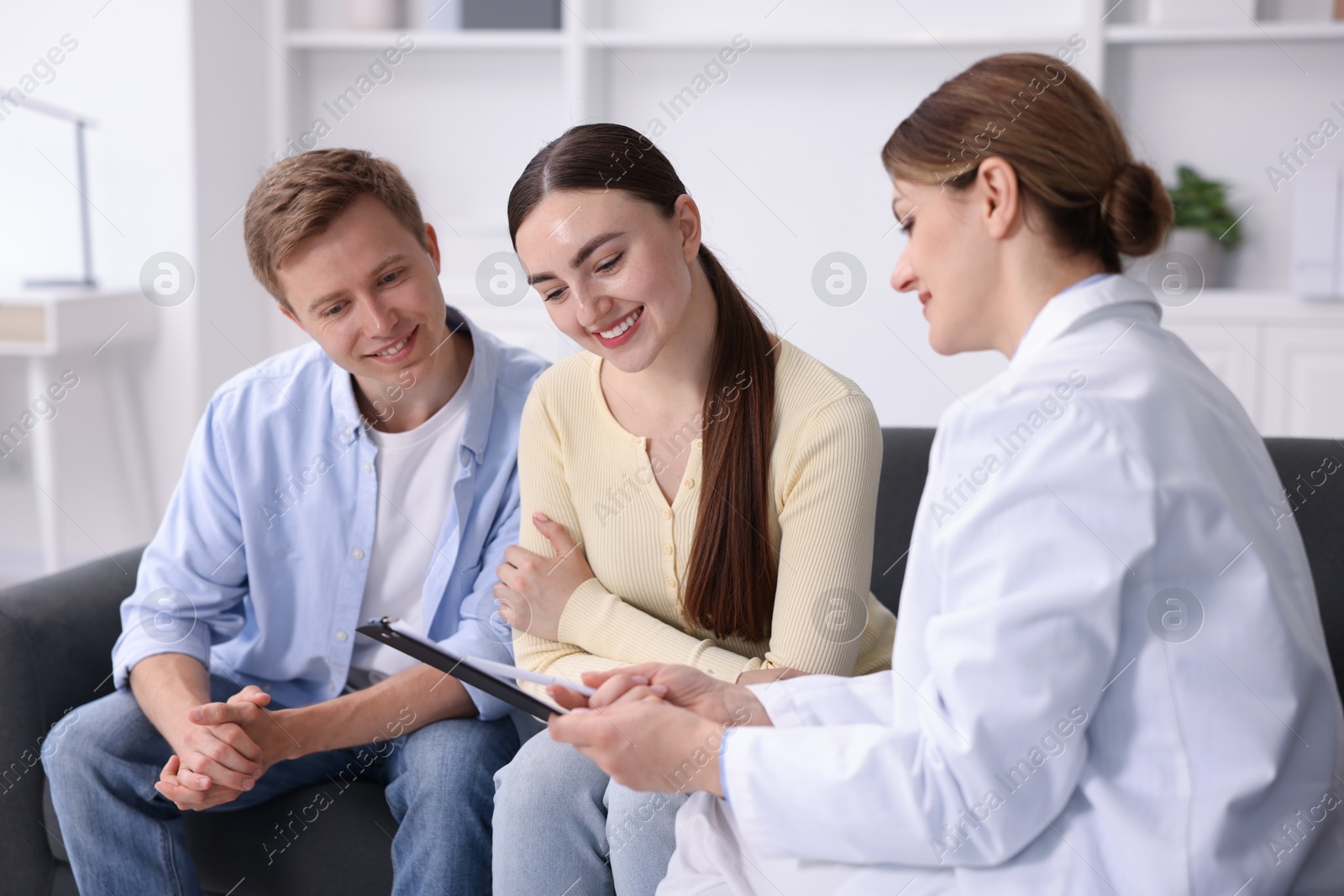 Photo of In vitro fertilization (IVF). Happy couple having appointment with doctor in reproductive clinic