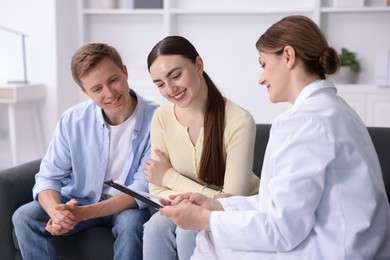 Photo of In vitro fertilization (IVF). Happy couple having appointment with doctor in reproductive clinic