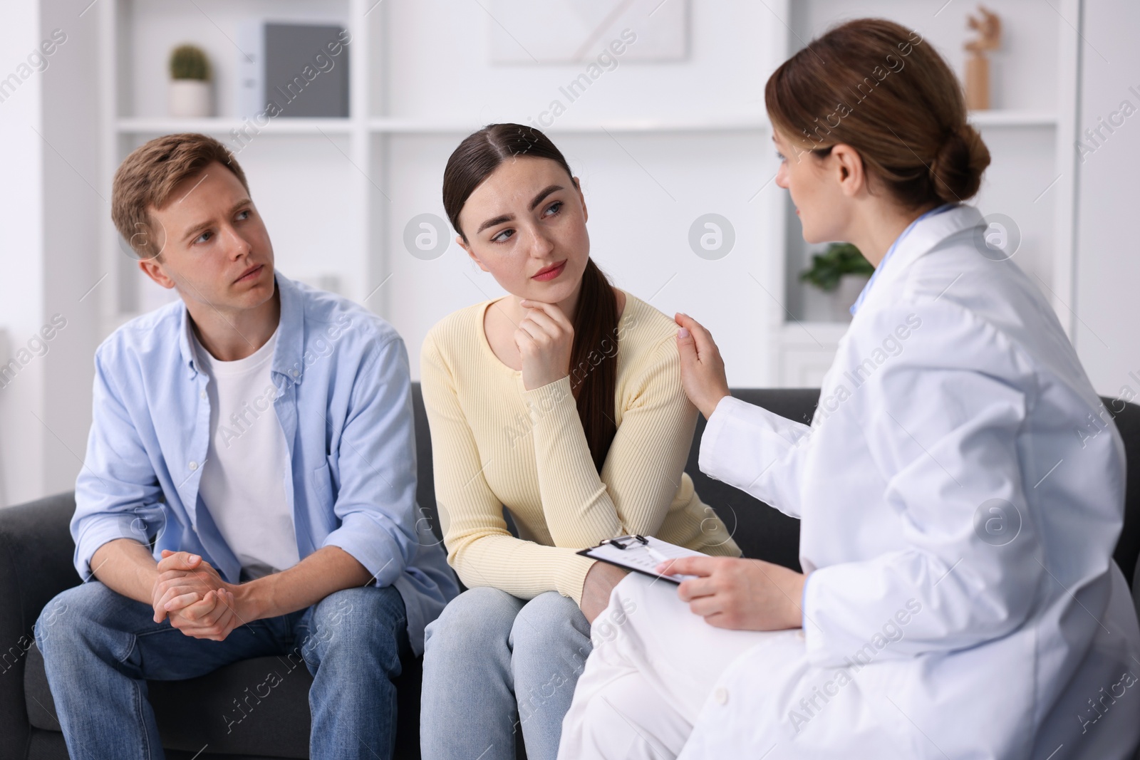 In vitro fertilization (IVF). Doctor supporting upset couple during visit in reproductive clinic Photo of In vitro fertilization (IVF). Doctor supporting upset couple during visit in reproductive clinic
