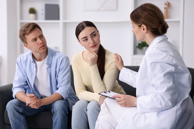 Photo of In vitro fertilization (IVF). Doctor supporting upset couple during visit in reproductive clinic
