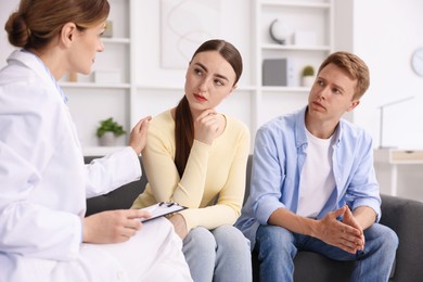 Photo of In vitro fertilization (IVF). Doctor supporting upset couple during visit in reproductive clinic