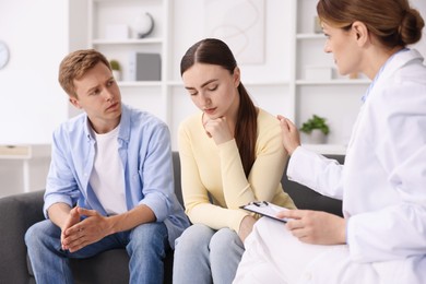 Photo of In vitro fertilization (IVF). Doctor supporting upset couple during visit in reproductive clinic