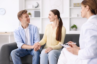 Photo of In vitro fertilization (IVF). Couple holding hands during appointment with doctor in reproductive clinic