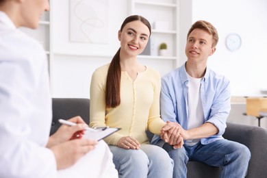 Photo of In vitro fertilization (IVF). Couple holding hands during appointment with doctor in reproductive clinic