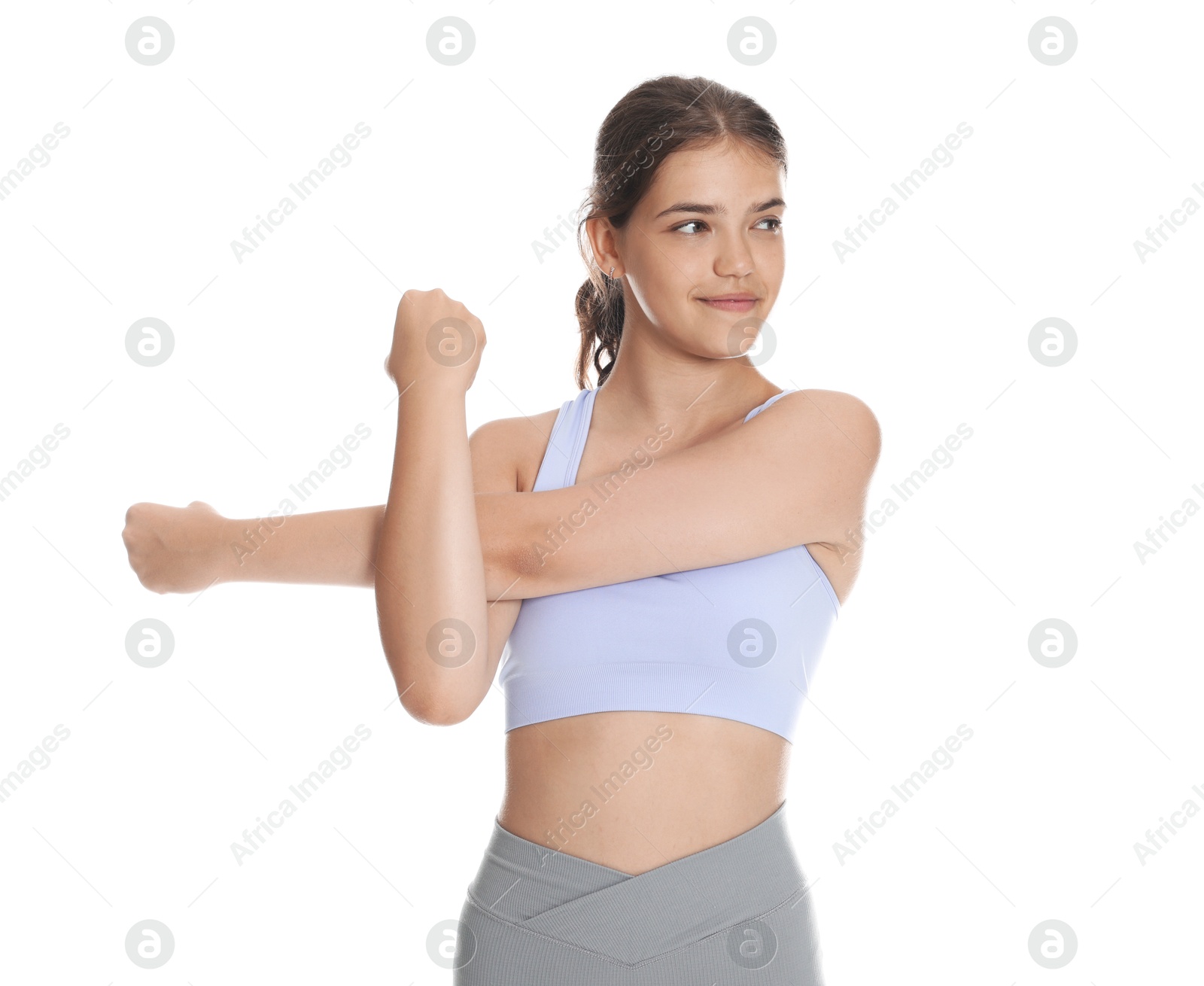 Teenage girl in sportswear stretching on white background Photo of Teenage girl in sportswear stretching on white background