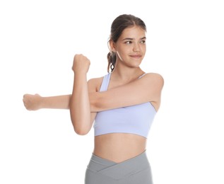 Photo of Teenage girl in sportswear stretching on white background