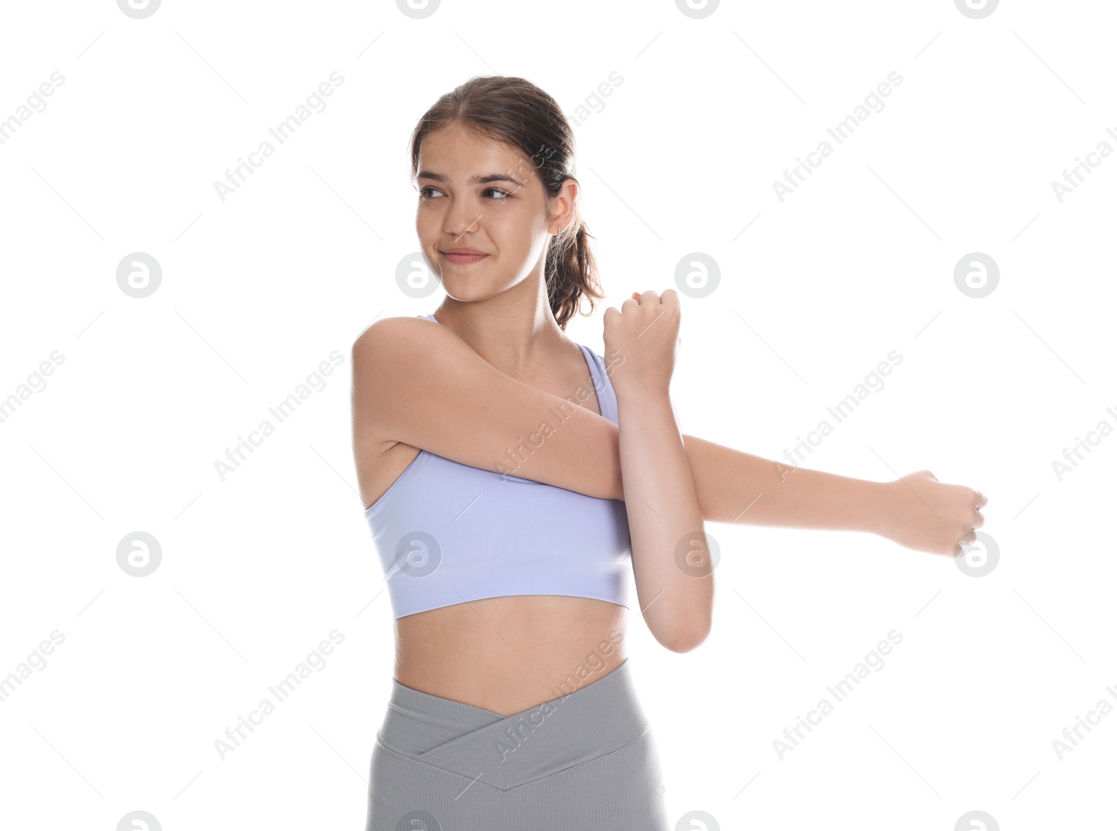 Teenage girl in sportswear stretching on white background Photo of Teenage girl in sportswear stretching on white background