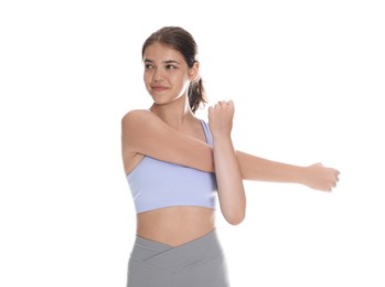 Photo of Teenage girl in sportswear stretching on white background