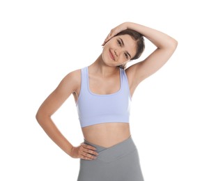 Photo of Teenage girl in sportswear stretching on white background
