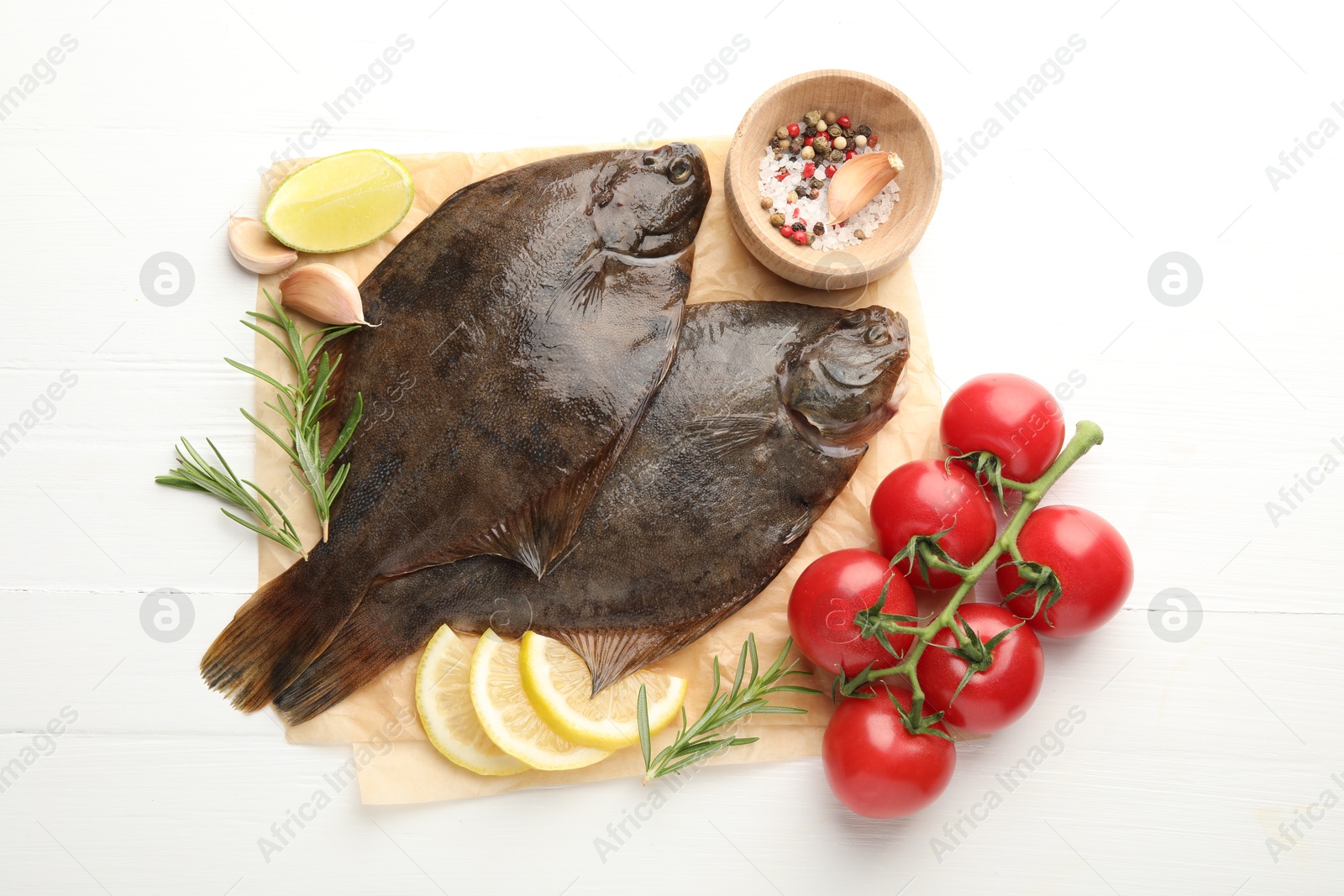Fresh raw flounder fish and ingredients on white wooden table, flat lay. Seafood Photo of Fresh raw flounder fish and ingredients on white wooden table, flat lay. Seafood