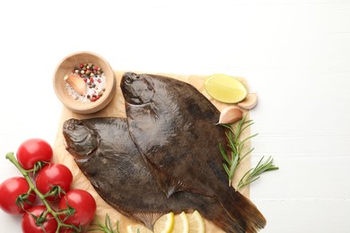 Photo of Fresh raw flounder fish and ingredients on white wooden table, flat lay. Seafood