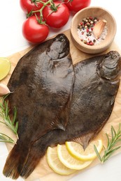Photo of Fresh raw flounder fish and ingredients on white wooden table, flat lay. Seafood