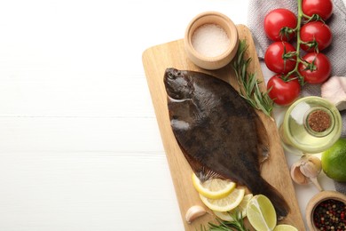 Photo of Seafood. Fresh raw flounder fish and ingredients on white wooden table, flat lay. Space for text