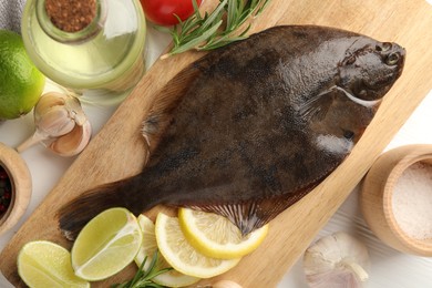 Photo of Fresh raw flounder fish and ingredients on white wooden table, flat lay. Seafood