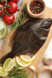 Photo of Fresh raw flounder fish and ingredients on table, flat lay. Seafood