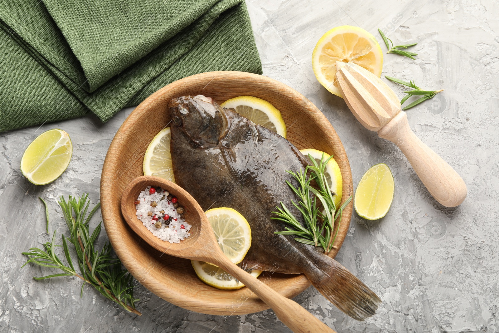 Fresh raw flounder fish, spices and wooden juicer on grey table, flat lay. Seafood Photo of Fresh raw flounder fish, spices and wooden juicer on grey table, flat lay. Seafood