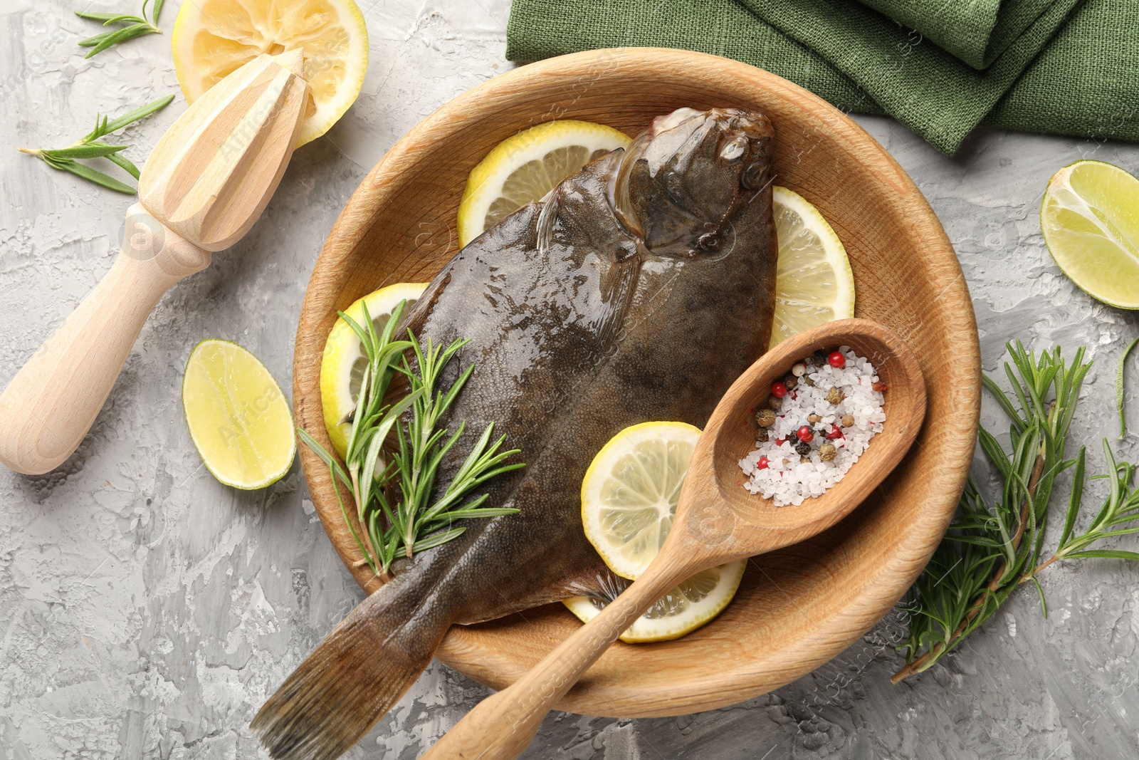 Fresh raw flounder fish, spices and wooden juicer on grey table, flat lay. Seafood Photo of Fresh raw flounder fish, spices and wooden juicer on grey table, flat lay. Seafood