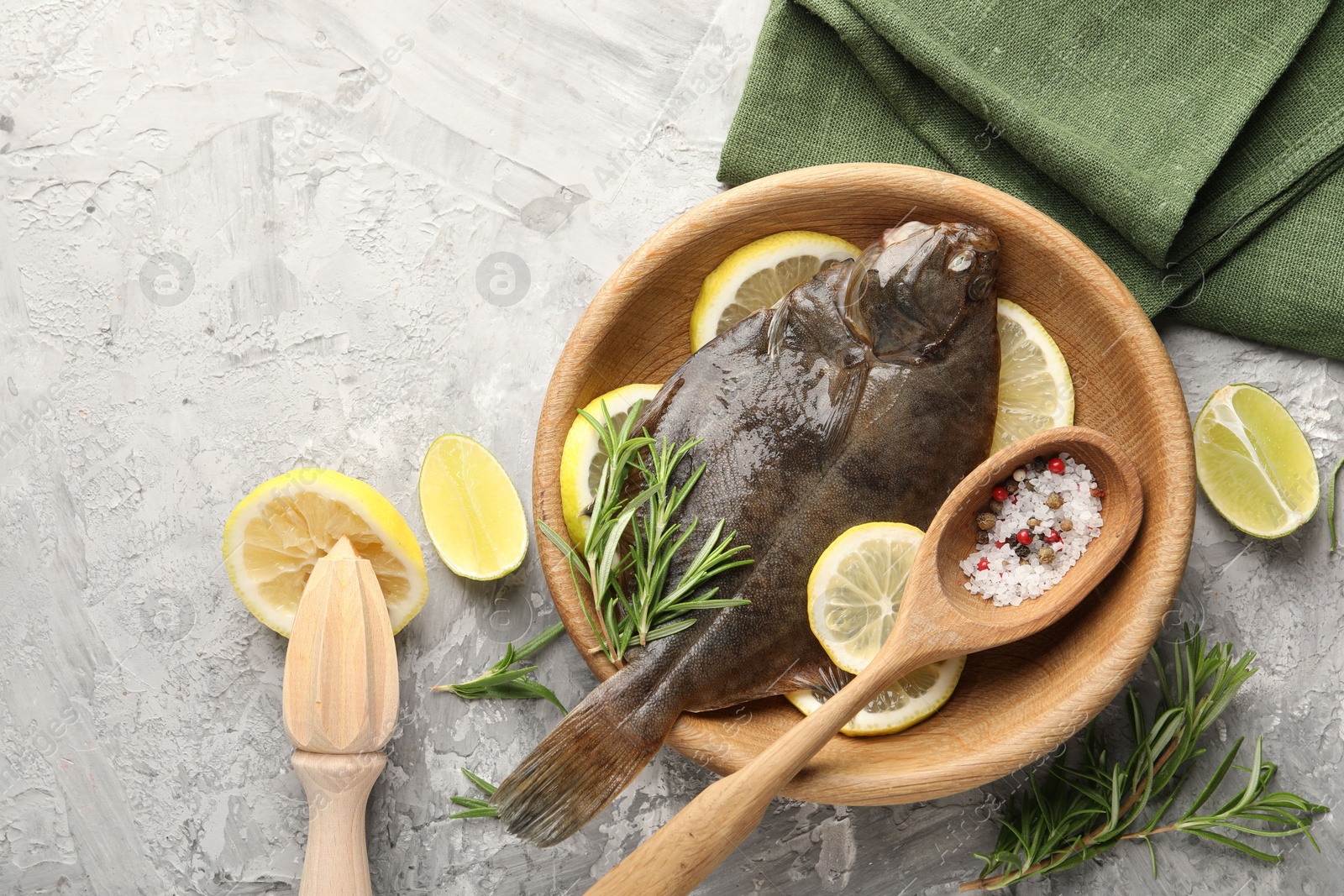 Fresh raw flounder fish, spices and wooden juicer on grey table, flat lay. Seafood Photo of Fresh raw flounder fish, spices and wooden juicer on grey table, flat lay. Seafood